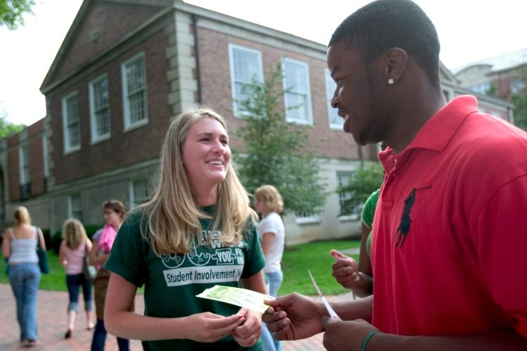 Laura Ulmer and Jerome Williams chat during the activities fair held for a first-year class on the College Green.