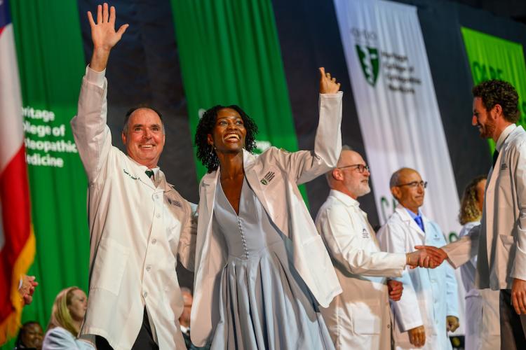 Executive Dean Ken Johnson and a student from the Class of 2029 wave to the crowd
