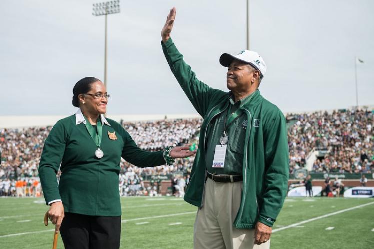 President Emeritus Roderick J. McDavis and First Lady Emerita Deborah McDavis wave to the crowd at a Homecoming football game in Peden Stadium