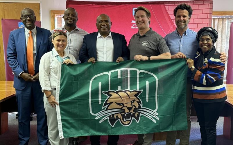 Representatives of Ohio University and the University of Botswana hold an OHIO flag while at the University of Botswana