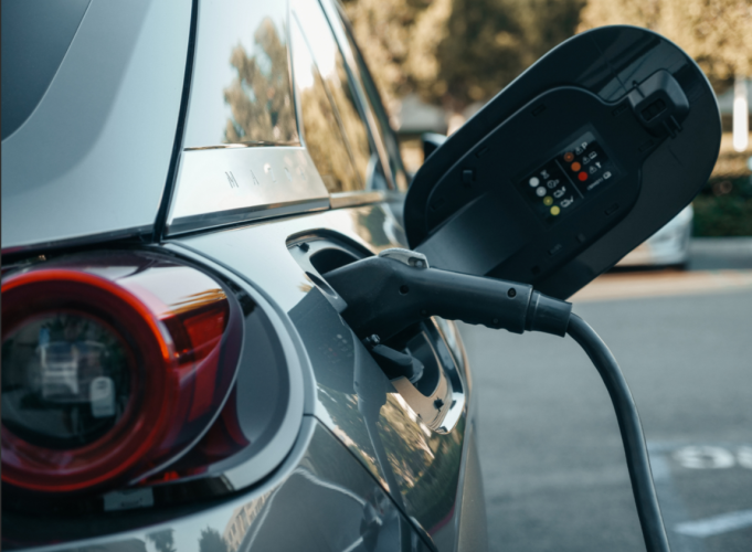 An electric or hybrid car is shown while being charged