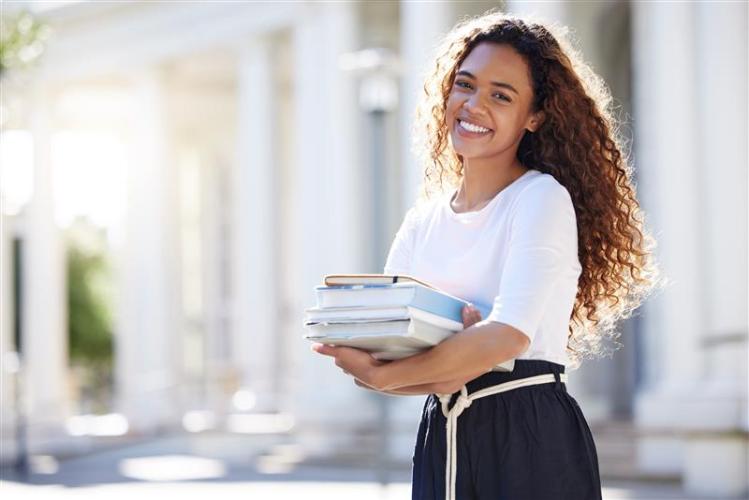 A college student is shown holding textbooks