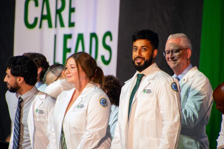HCOM students receive their white coats during convocation.