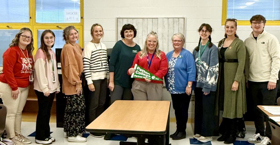 OHIO Zanesville and Zane Grey Elementary School representatives stand together for a photo inside of an elementary school classroom