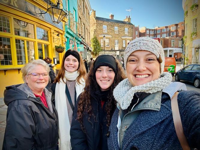 OHIO students and faculty member Teri Peasley stand together on a busy sidewalk in England