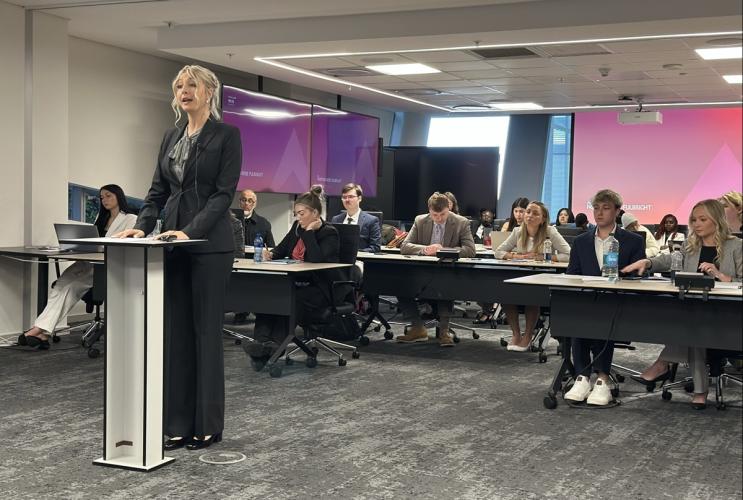 An OHIO student stands up and gives a professional presentation in front of other students and faculty