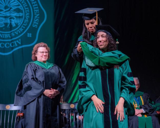 Student is hooded at HCOM commencement