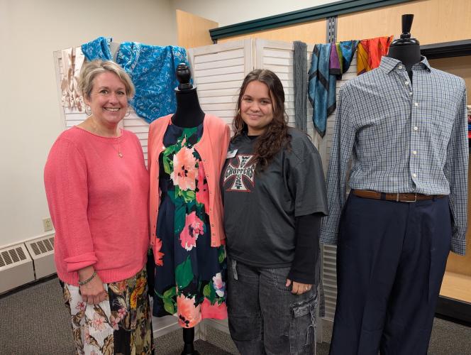 Two women standing beside clothing display