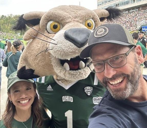 Gregg Patner stands with OHIO's Rufus mascot and another individual at an OHIO football game in Peden Stadium
