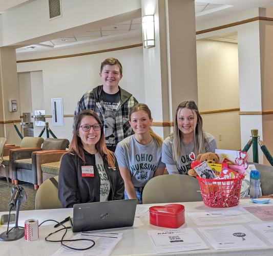 student nurses sit behind registration table at blood drive
