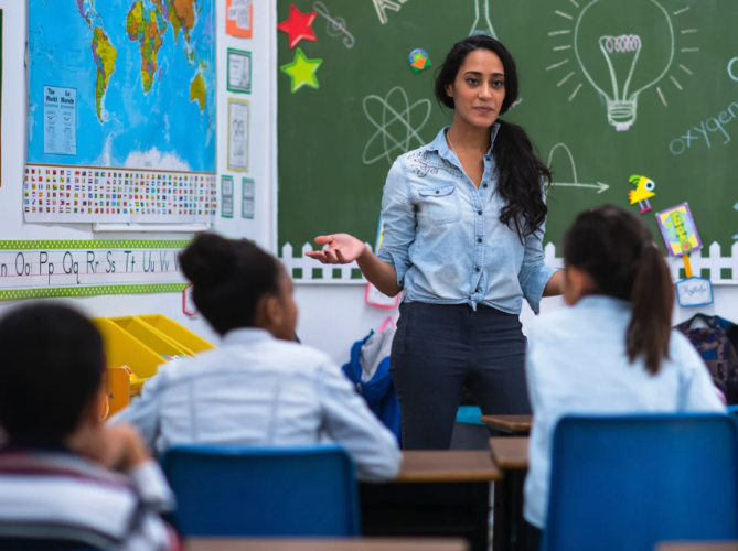 teacher standing in front of elementary classroom