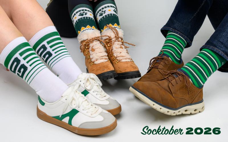 The image shows three people wearing different Socktober socks and the words "Socktober 2026"