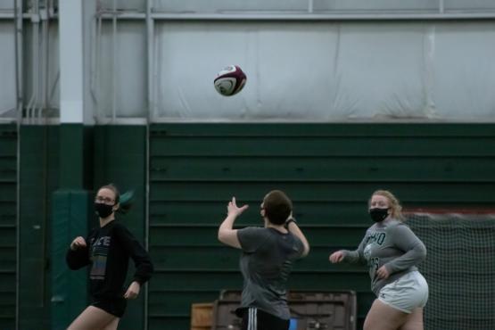 Students of the Women's Rugby team practice inside of Walter Fieldhouse.