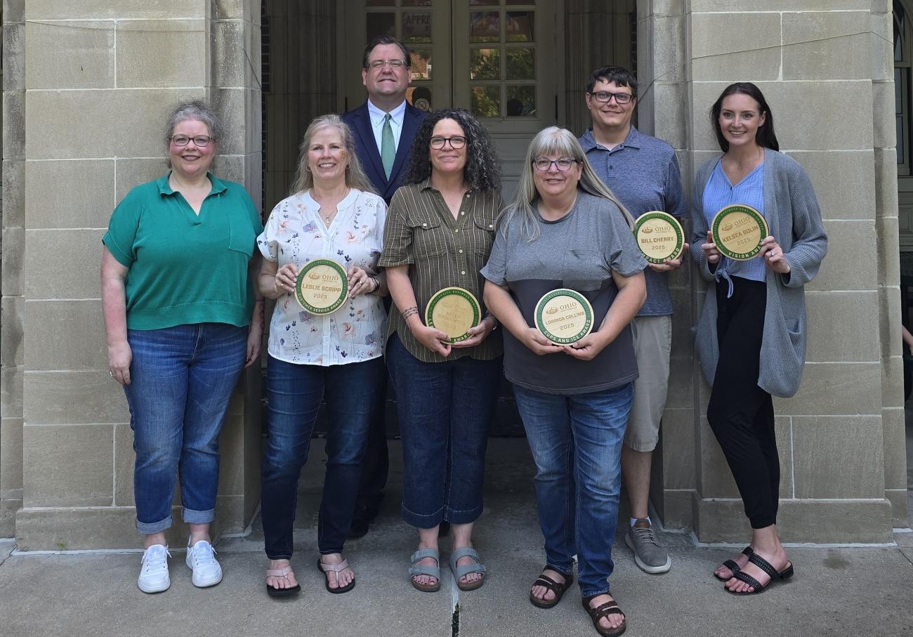 Dave Moore and Heather Krugman stand with employee award winners at the Business Service Center employee appreciation event