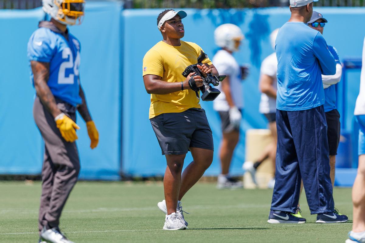 Jaylen Bannerman-Oden holds a camera during a Los Angeles Chargers practice.