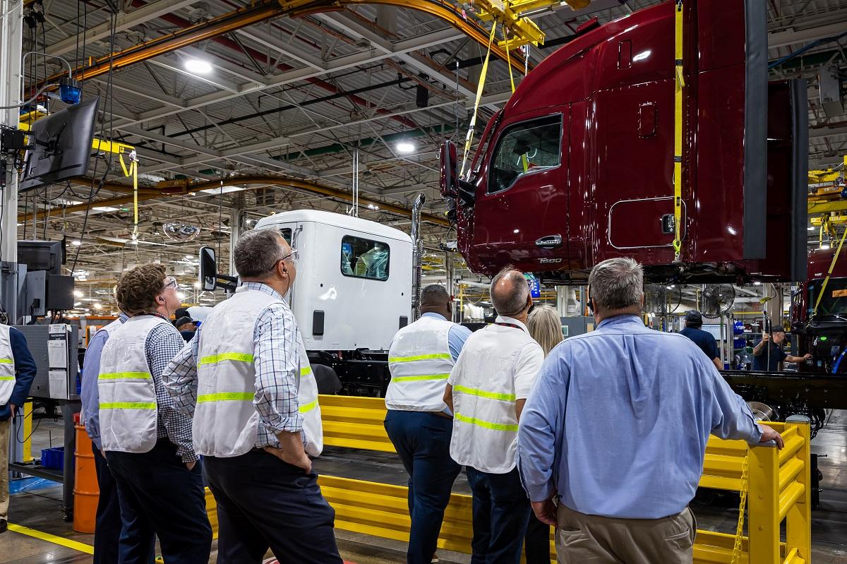 OHIO and Kenworth leaders look at the front of a semi truck while they tour the Kenworth Plant in Chillicothe