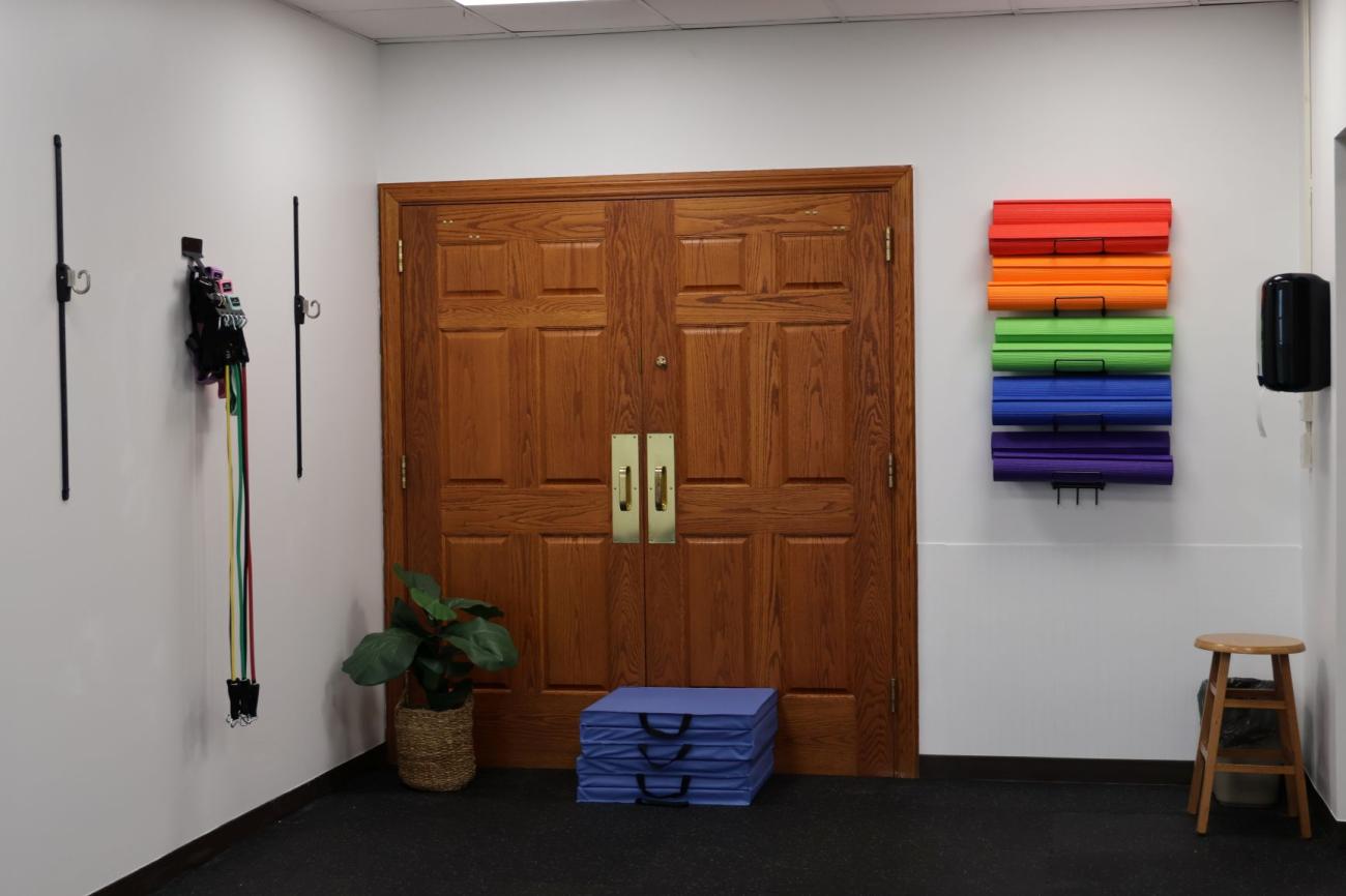 Fitness area, with resitance bands and yoga mats neatly hanging on racks on the walls