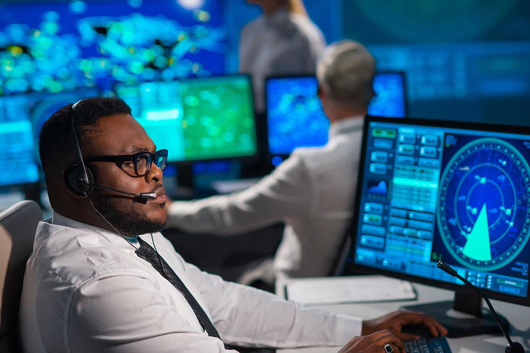 An air traffic controller works at a desk.
