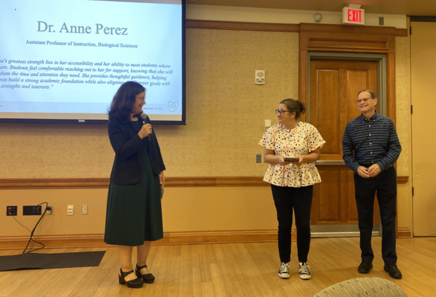 Jenny Klein speaks about Anne Perez, while Perez and David Descutner stand nearby at the awards ceremony