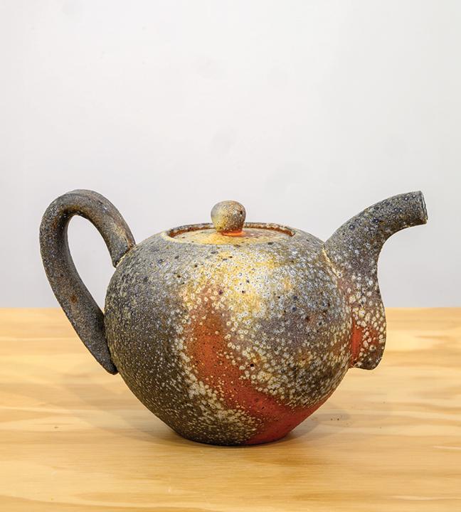 a gray, yellow and orange ceramic teapot
