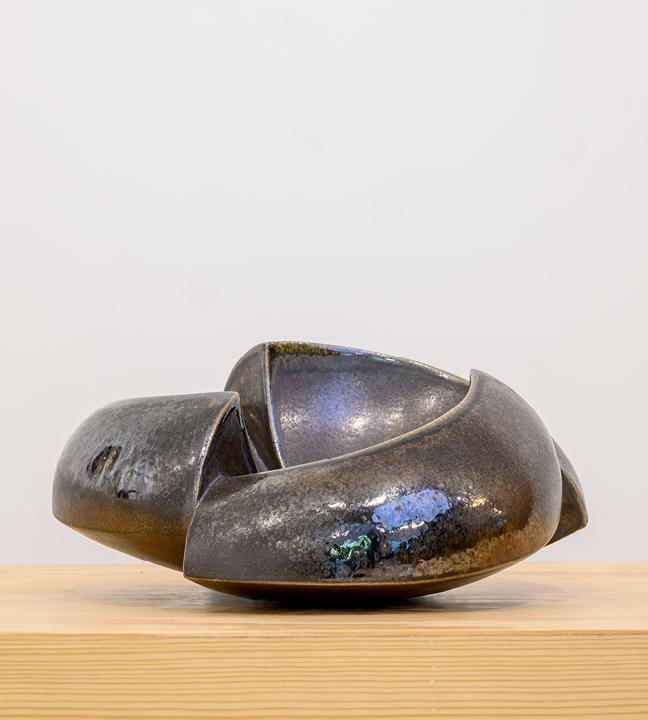 a bronze ceramic bowl that’s split and reassembled so as to be partially open