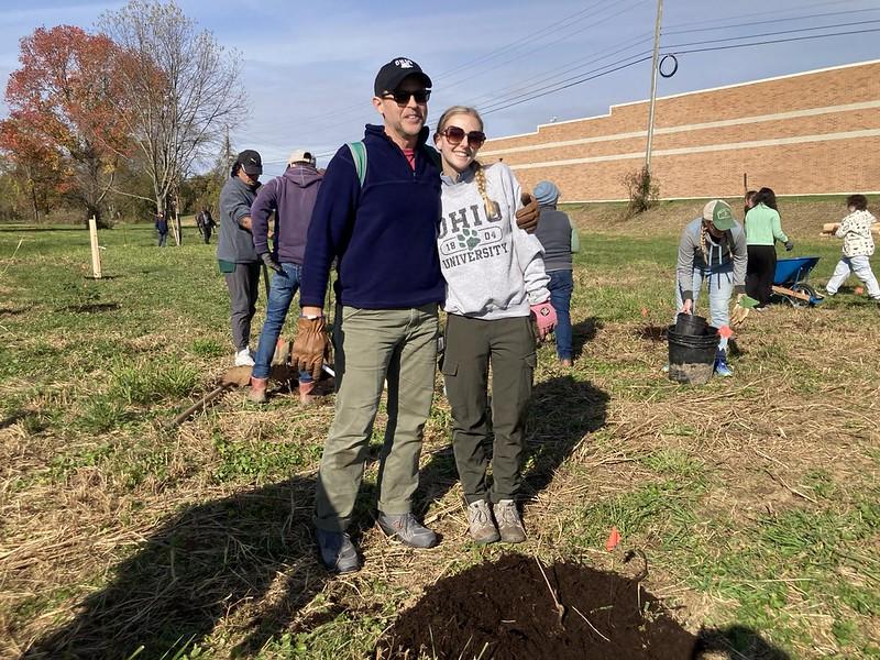 OHIO student Eva Miller and her father pose for a photo during the tree planting event
