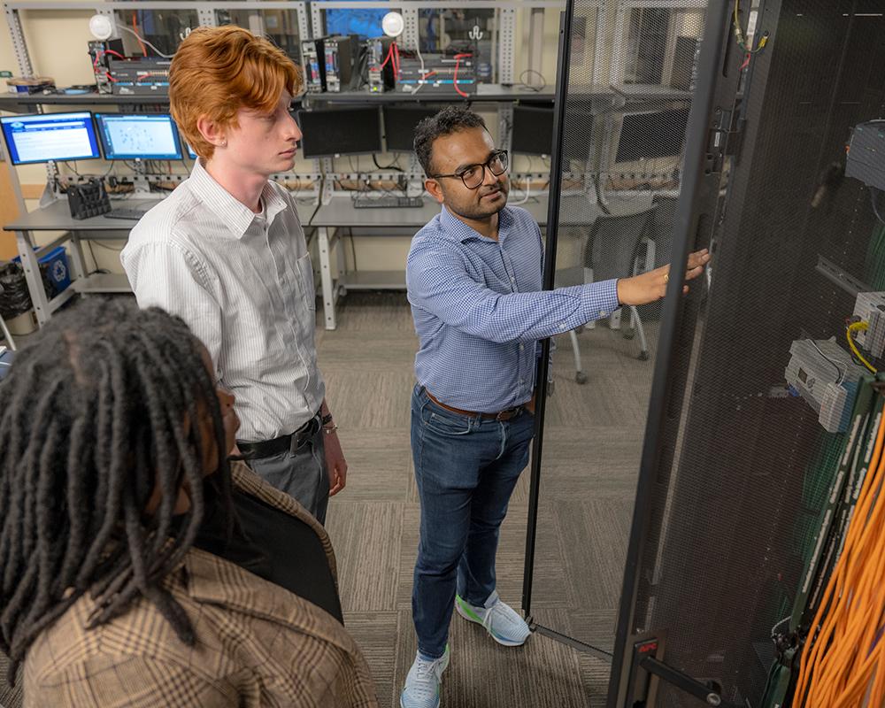 Ohio University Assistant Professor Rishabh Das works with students on cybersecurity measures.