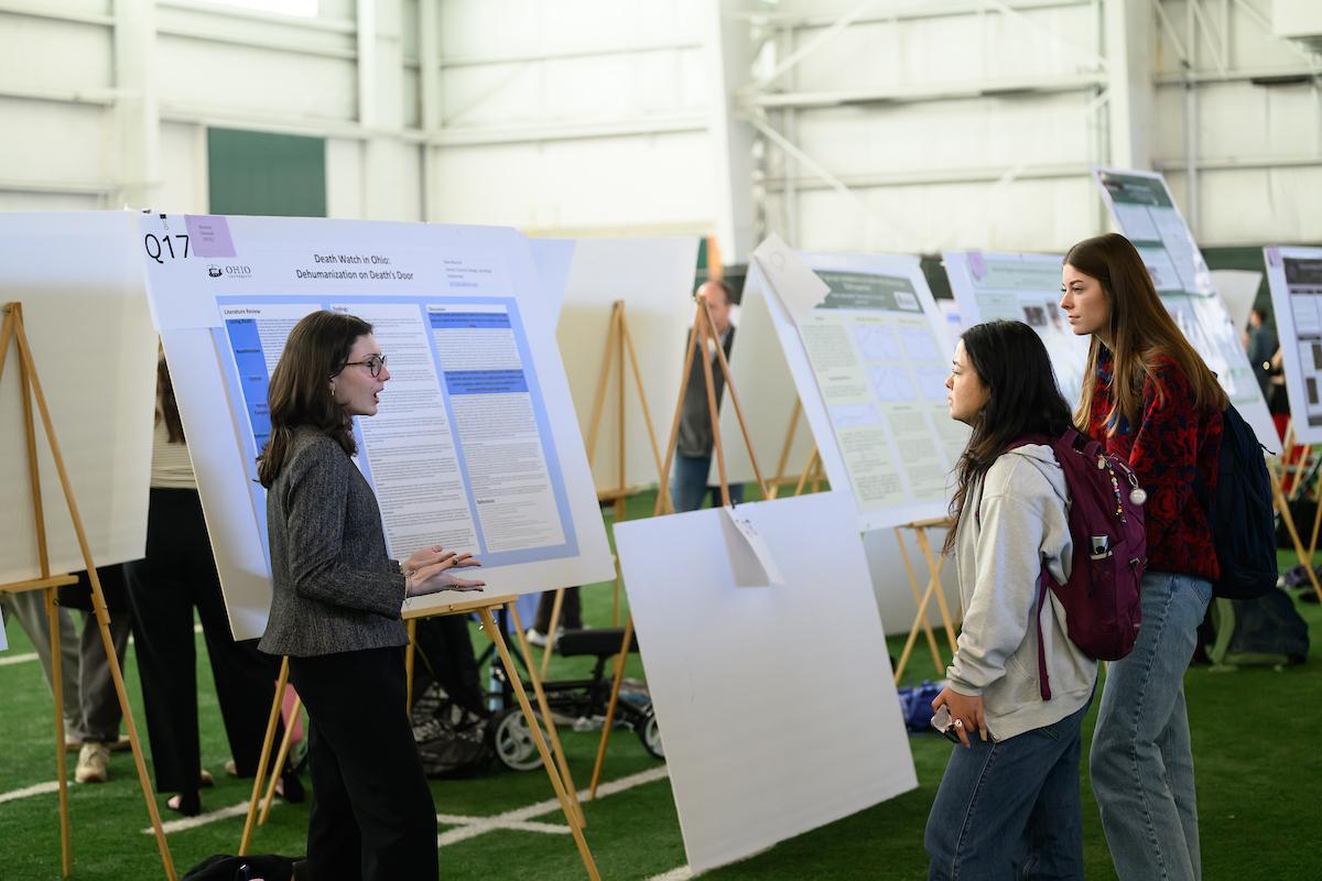 An Ohio student talks with two other students about a research project at the Student Research Expo