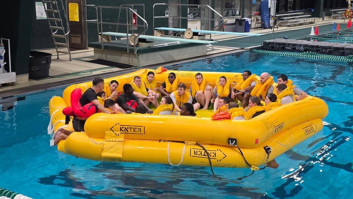 Members of the Ohio University Air Force ROTC are shown  in a very large inflatable raft in a pool