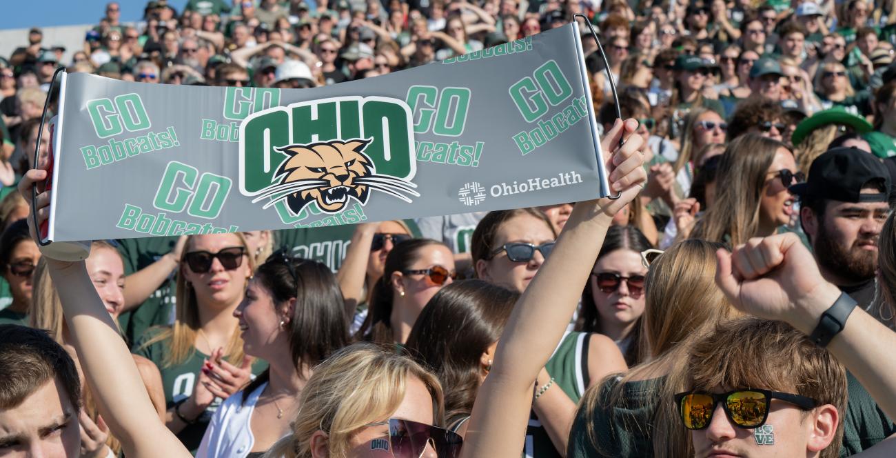 Students hold up an Ohio University sign during a football game. 
