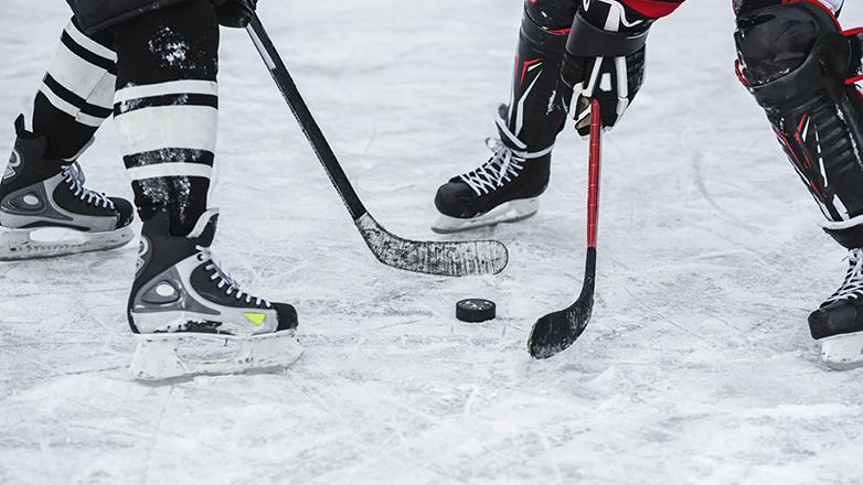 Two hockey players line up ready to battle for the puck.