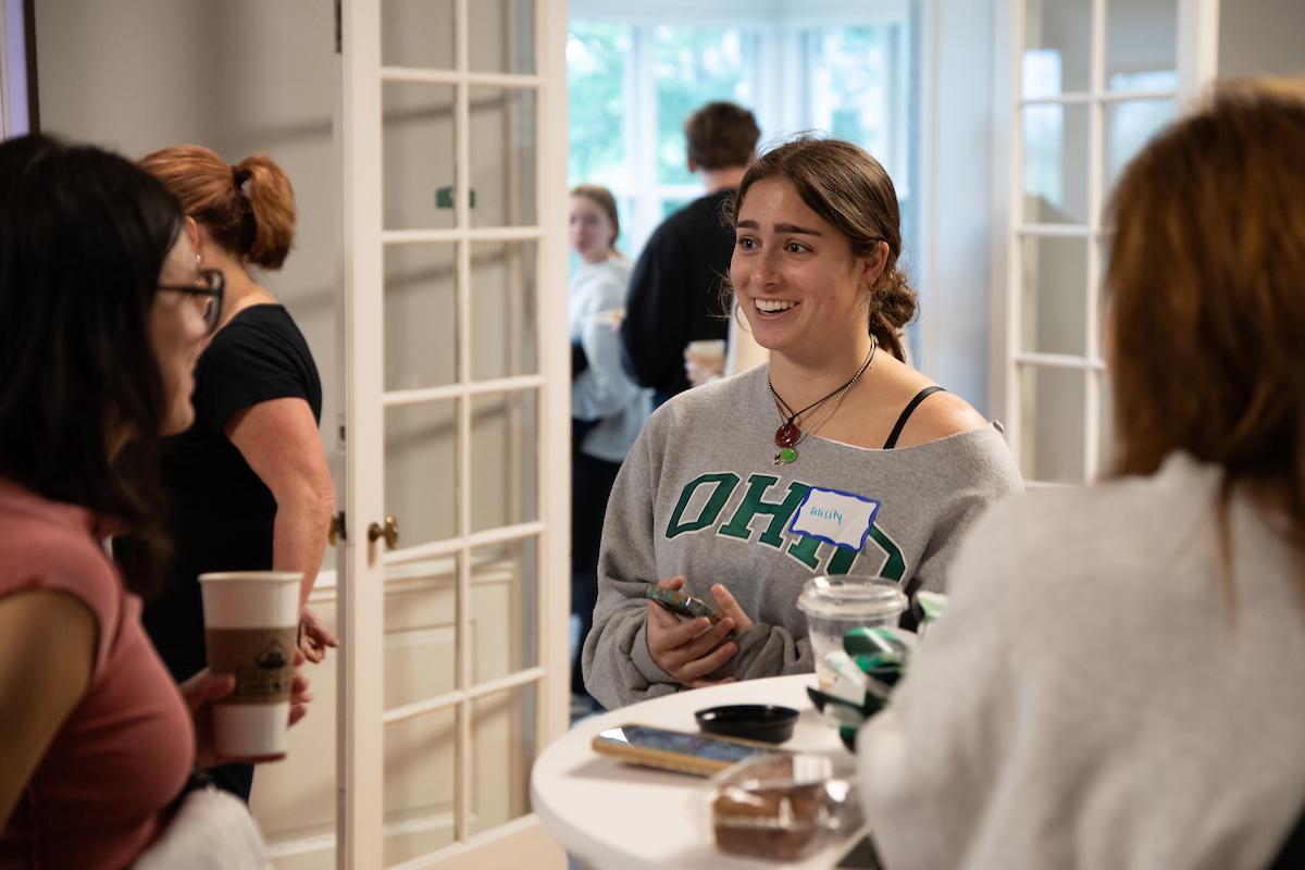 An OHIO student enjoys a warm drink with family at the Tea With The President event