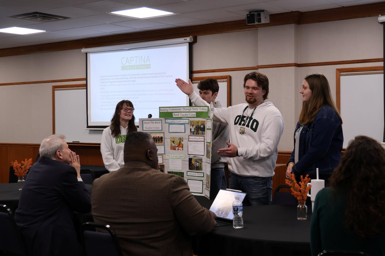 Students presenting to a group of education professionals