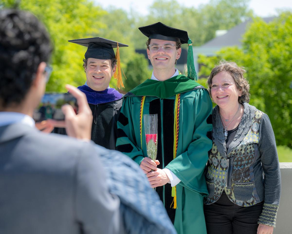 HCOM graduate poses for photo after commencement