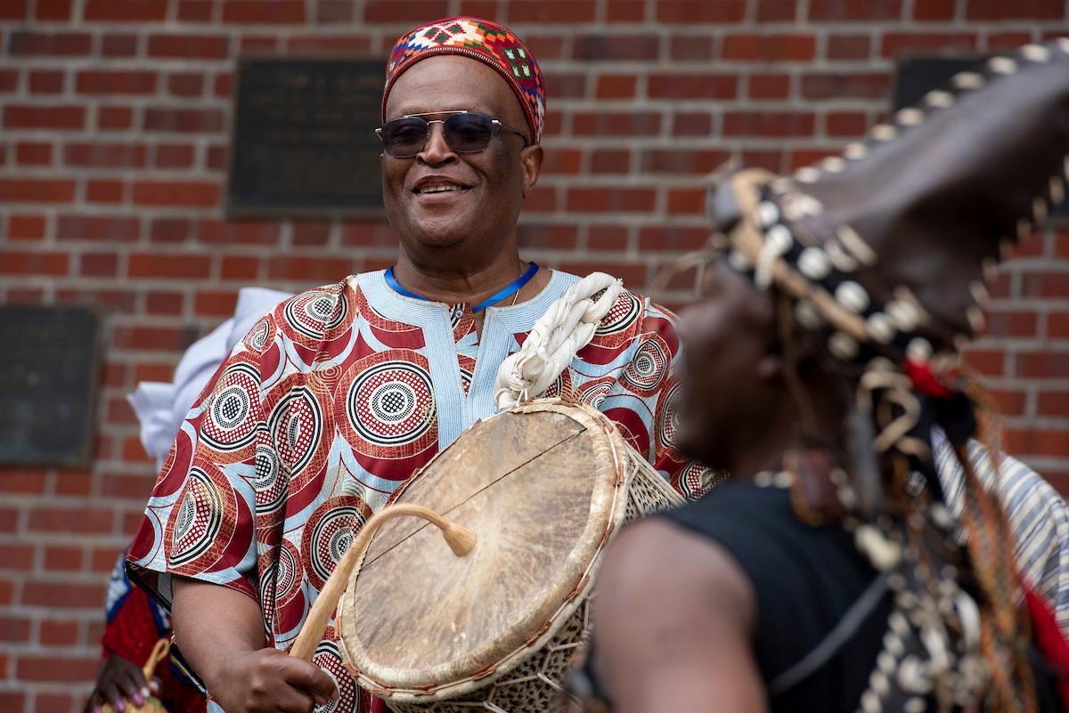 Paschal Yao Younge plays a drum at a performance