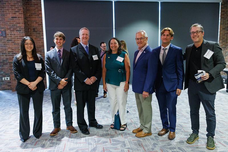 A group of seven student interns and program representatives stand together 