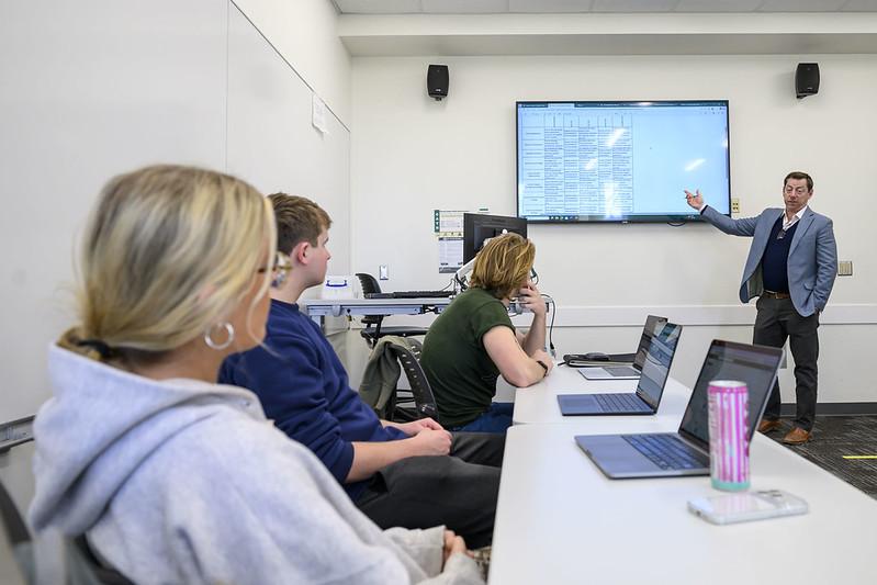 OHIO students in a classroom with computers in front of them listen to a class presentation