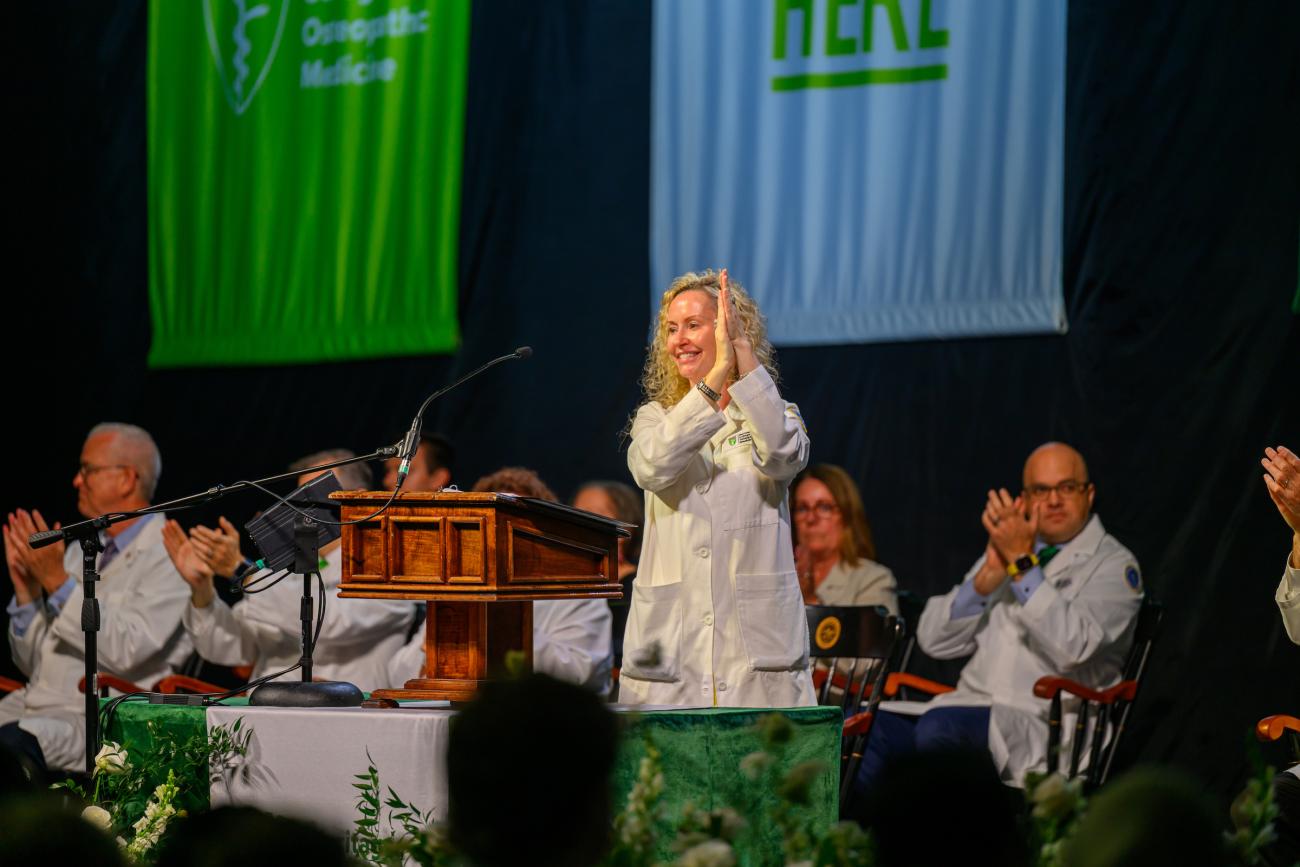 HCOM Interim Senior Dean Gwilym applauds on stage