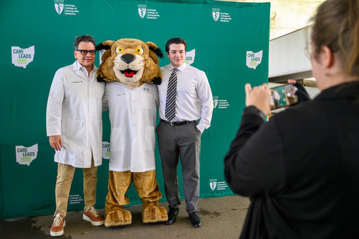 HCOM student poses with Rufus at convocation