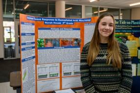 Norah House is shown standing in front of her project at Science Day
