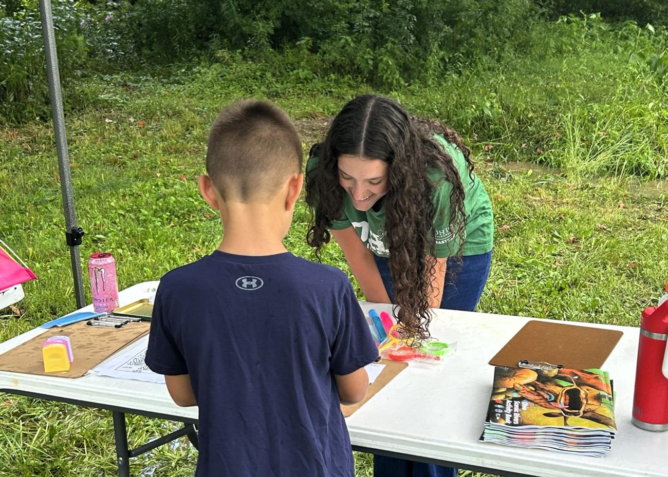 Trista Regis helping a child with a game.