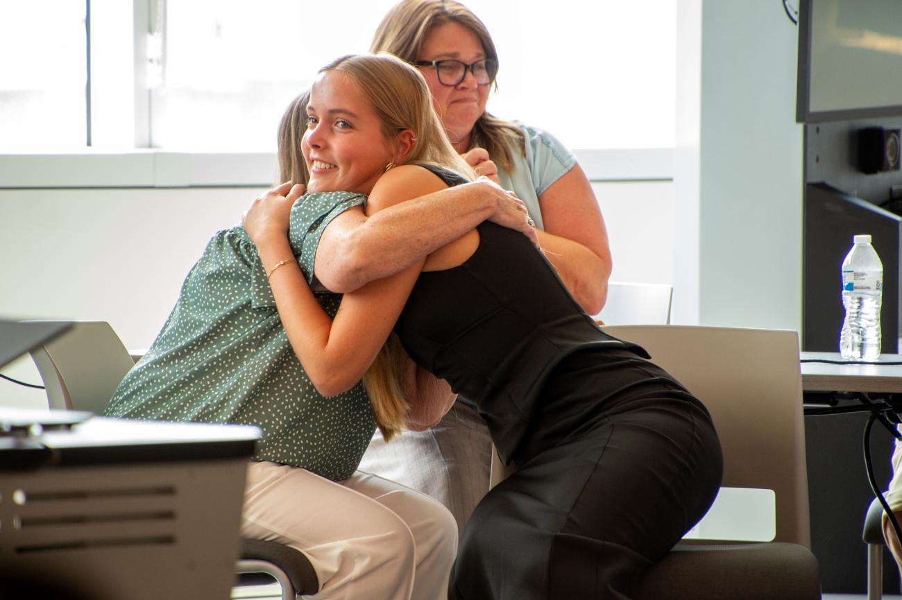 Student hugs family member after scholarship announcement