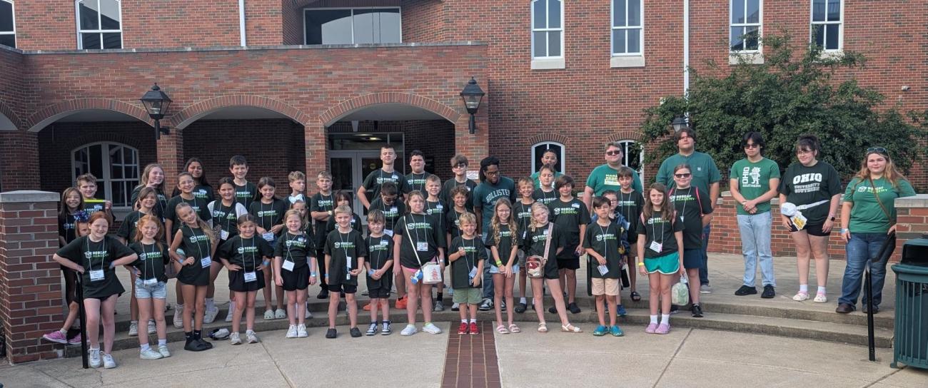 The campers and staff members from the Bobcat Academy stand together outside for a photo
