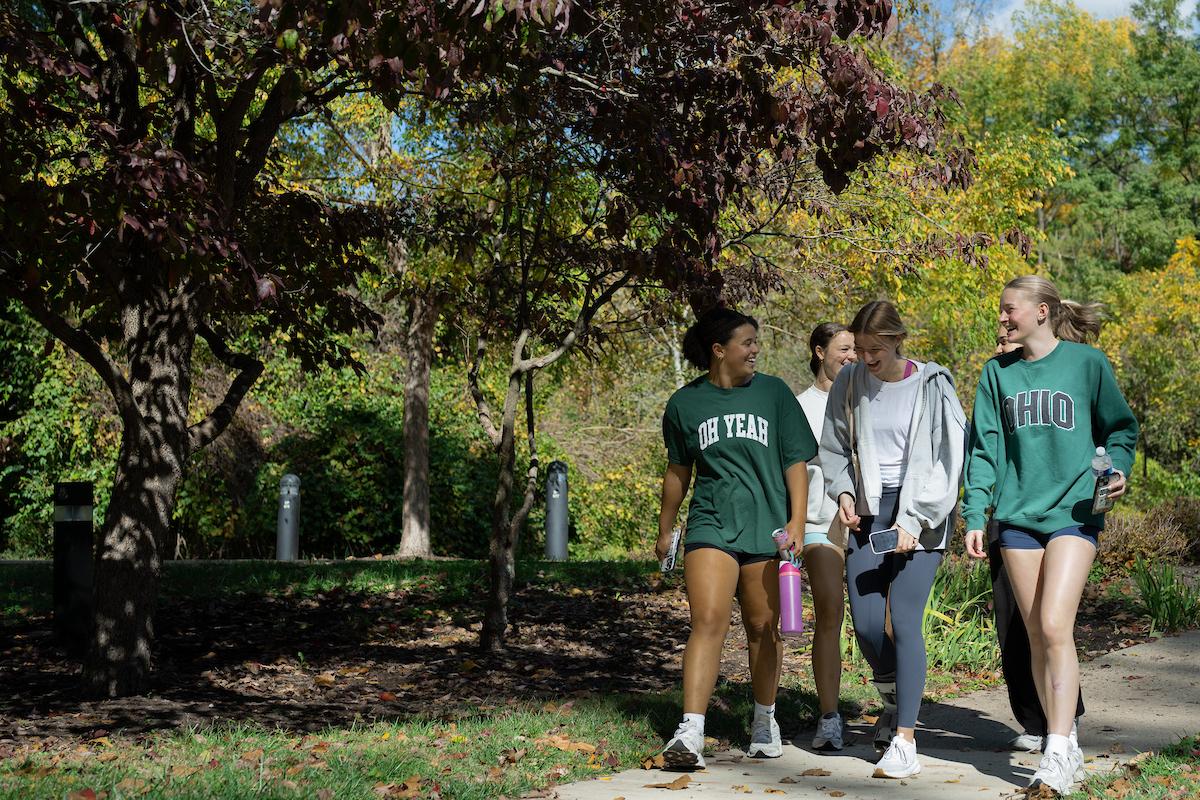 OHIO Students walk on a path and  laugh together during a Fall day at Ohio University