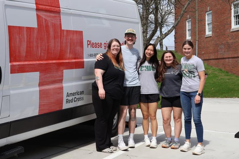 5 nursing students standing next to a Red Cross Van