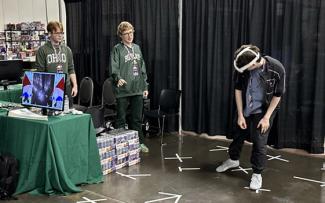 Ben King and William Hamilton explaining their game Gnome Invasion to a GDEX attendee