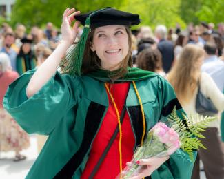 Student holds cap at HCOM commencement