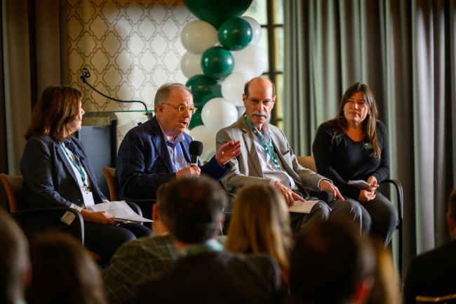 Four panel members lead a discussion on the stage at the State Government Alumni Luncheon