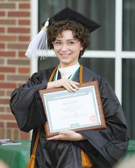 An OHIO Graduate shows off her diploma at the Ohio University Southern Graduation Recognition Ceremony