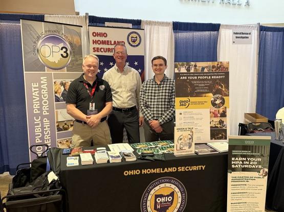 Three individuals stand behind an Ohio Homeland Security booth